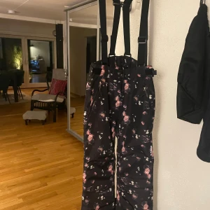 Termobyxor - Jag säljer ett par blommiga termobyxor som nu inte passar längre! Dem är väldigt varma och sköna. Det är en knapp som saknas på framsidan  men det finns knappar till. Det påverkar inte knäppningen för att det går fortfarande att knäppa. Storlek 152!!