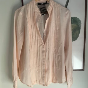 Karl Lagerfeld blus - Oanvänd. Liten fläck enligt bild, därav lågt pris.