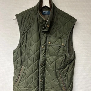 Grön gw väst från Polo Ralph Lauren - Säljer en snygg grön quiltad väst från Polo Ralph Lauren. Perfekt för höst och vår när du vill hålla stilen utan att frysa. Ganska stor i storleken går lätt om du är M. Bra skick sparsamt använd. 
