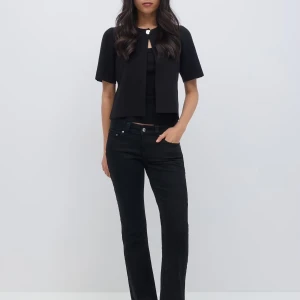 Svarta bootcut jeans - Snygga svarta bootcut jeans med en klassisk design. De har en lågmidjad passform och är perfekta för en stilren look. Jeansen har en enkel design med knappar och dragkedja framtill.