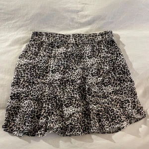 Leopardmönstrad kjol - Snygg leopardmönstrad kjol med en lätt utsvängd form. Perfekt för att ge din outfit en trendig touch. Kjolen har en bekväm passform och är lätt att matcha med olika toppar.