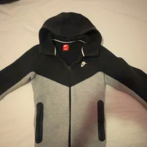 Nike tech hoodie - Säljer Nike tech hoodie. Köpte för 1500 men har haft dem ett tag nu.Den har lite färg på ena armen men skulle annars säga den är bra. Pris går att diskutera 🙌