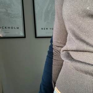 Figursydd stickad tröja  - Modern marinblå stickad tröja med lång ärm och ribbade detaljer. Perfekt för en stilren look och passar bra till jeans, kostymbyxor eller kjol. Ett måste i garderoben för den som gillar moderna plagg. (Säljer även jeansen)