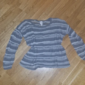 Grå och vit randig stickad tröja från Monki - Säljer en tunn grå och vit randig tröja från Monki. Tröjan är stickad med långa ärmar och har en avslappnad passform. Perfekt för att layera outfits. Hör av dig vid intresse! 😊 det står xs/s men passar medium också!