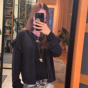 Gina kofta volangdetaljer - Säljer en marin blå/ navy blue kofta med volangdetaljer på ärmarna.❤️ Koftan har en ribbad kant och en stjärna i guld som knapp. St 170!! Har även en extra knapp!❤️