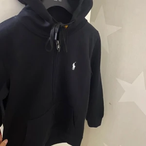 Svart hoodie från polo  Ralph Lauren - Jag säljer denna fina polo Ralph Lauren tröjan som I jag har använt knappt den ser ut o vara ny inga skador eller liknande skrev för mer information och jag kan tänka mig gå ner i priset vid snabb affär