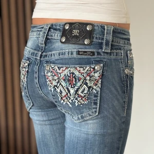 Miss me jeans - Lågmidjade bootcut jeans från miss me. Snygg design. Bra skick, se bild. Mått: Innerbenslängd: 84cm   Midjemått rakt över: 33,5cm Modellen är 166cm lång. Fler bilder finns. Skriv gärna ifall du har några frågor! 💗 OBS se slitningar/hål längst ner bak på byxbenen