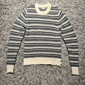 Acne studios tröja - Stickad Acne studios tröja. Den är köpt andrahand och ser använd ut, skicket är bra dock förutom lite slitningar längst ner i resåren och en fläck på armen som förmodligen går bort! Priset är inte hugget i sten!