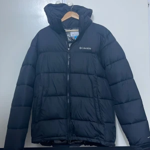 Svart dunjacka från Columbia - Säljer en svart dunjacka från Columbia med dragkedja och huva i storlek L. Bra skick, nypris runt 2000kr. Pris går att 