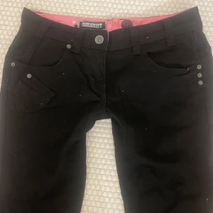 Lågmidjade svarta jeans  - Snygga svarta byxor från Pineapple studios med en klassisk design. Byxorna har en lågmidjad passform. De är raka men går enkelt att sys om till bootcut. Midjemåttet är 43 cm tvärs över och innerbens byxlängden 93 (ej innerbens längden!!) byxbensvidd 18 cm 