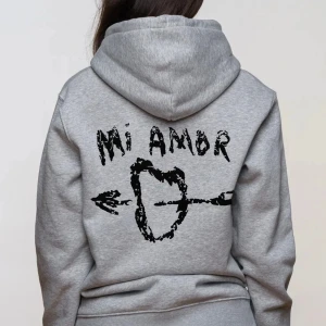 Grå hoodie med tryck - Säljer en grå Mi Amor hoodie, ficka där fram. Original pris runt 1500kr, priset går alltid att diskutera.