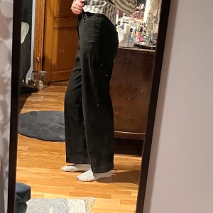 Monki byxor - Svarta byxor från Monki. Byxorna är wide och high waist, med dragkedja och bak och framfickor. Byxorna har inga defekter. Midjelängd:37 cm. Innerbenslängd: 76 cm. Jag är 174 cm. Säljer eftersom den är för små. 