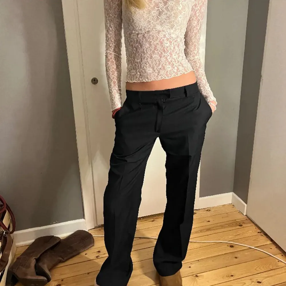 Snygga svarta kostymbyxor med en klassisk passform. De har en rak stil och är perfekta för en stilren look. Byxorna har en midwaist och är tillverkade i ett bekvämt material.. Farkut & Housut.
