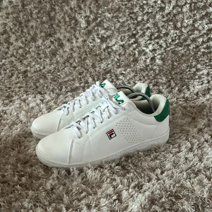 Vita sneakers från Fila - Snygga vita sneakers från Fila med gröna detaljer och klassisk snörning. Använda en gång  (SKICK 10/10) box med följer ej🔥hör av dig vid minsta fundering!🤝