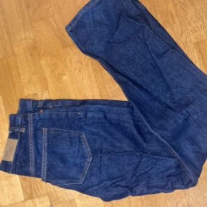 Blå jeans - Snygga blå jeansbyxor med klassisk design. De har en rak passform och fem fickor. Perfekta för en avslappnad stil.