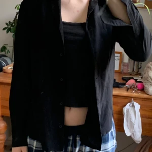 Svart skjorta från Uniqlo - stilren svart skjorta från Uniqlo. Skjortan har långa ärmar och knappar framtill.