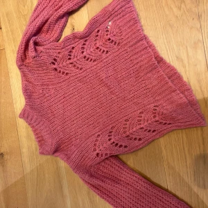Rosa stickad tröja från Odd Molly - Säljer en superfin rosa stickad tröja från Odd Molly. Tröjan har ett vackert hålmönster och långa ärmar. Perfekt för kyliga dagar när du vill vara både varm och stilren. Passar perfekt till jeans eller kjol!