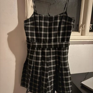 Svartvit rutig klänning - Kort snygg klänning med tunna axelband. Ej använd.