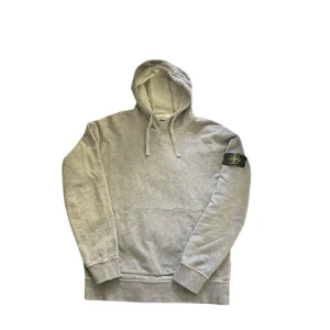 Grå hoodie från Stone Island - Mycket fin stone island hoodie nyskick, köpt för  på 3499kr på nordiska kompaniet. Mitt pris 1499kr. Storlek S/M, (kommer från hund och rök frit hem). Fraktas antigen samma dag som köp eller dagen därpå. Fraktas antigen samma dag som köp eller dagen därpå. Pris kan eventuellt diskuteras vid snabb affär🙌💯