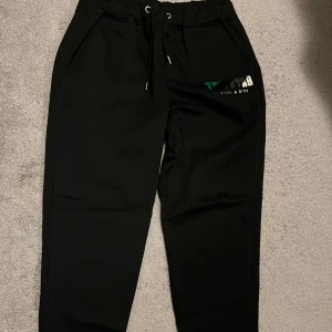 Svarta mjukisbyxor från trapstar - Snygga svarta mjukisbyxor från trapstar. De har en bekväm passform med snörning i midjan och praktiska fickor. Perfekta för en avslappnad stil.