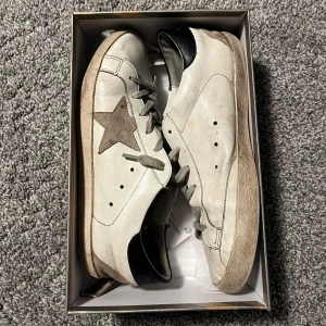 Golden goose skor - Snygga vita skor från golden goose. Skorna är inte äkta, köpte de på plick. Säljer billigt för vill bli av med de. Finns en rätt stor defekt längst bak på vänster sko. (Se bild 4) Fråga på vid frågor /Tom