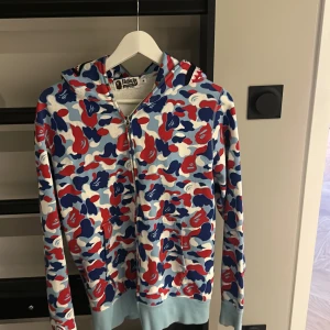 Flerfärgad camo hoodie från Bape - Säljer en cool flerfärgad camo hoodie från Bape med dragkedja och hajmotiv på huvan. Full zip skick 10/10 för endast 1800, ÄKTA. Pris kan diskuteras, bara testad. Hör av er vid frågor 