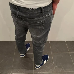 Grå jeans från Dondup - Snygga grå jeans från Dondup med en modern slim passform. De har en klassisk femficksdesign och en diskret logga på baksidan. Perfekta för en stilren look.