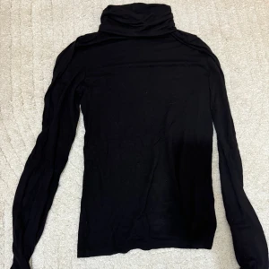 Svart polotröja från H&M Divided - Säljer en stilren svart polotröja från H&M Divided i storlek XS. Tröjan är långärmad och perfekt för både höst och vinter. 