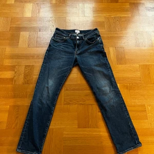 Mörkblå jeans från H&M Essentials - Säljer ett par mörkblå jeans från H&M Essentials i bra skick. De har en klassisk straight passform. Lite täcken på användning men inget spm sticker ut.