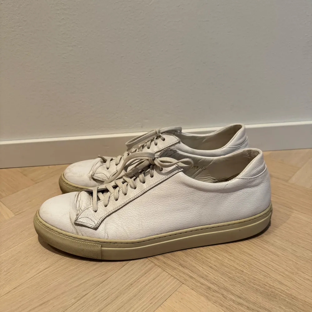 Säljer ett par vita lädersneakers med snörning från Sweyd i modellen 055. De har en klassisk design och är i bra skick med lite slitage på sulan. Perfekta för vardagsbruk och passar till det mesta i garderoben. Nypris 2899 kr säls för 1200 kr. Kengät.