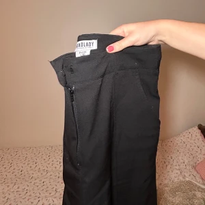Svarta byxor från Madlady - Säljer ett par stilrena svarta byxor från Madlady i storlek EU 36. De har en dragkedja på sidan för enkel på- och avtagning. Perfekta för både vardag och fest! 🖤