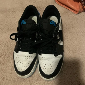 Nike Air Jordans i svart, vit och blå - Säljer ett par Nike Air Jordans i svart, vit och blå. Skorna har en klassisk design med snörning och är i bra skick. Perfekta för både vardag och fest! 🖤💙