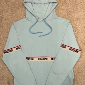 Hoodie från Moschino - Märke: Moschino Storlek: S Färg: Ljusblå Skick: Mycket bra skick