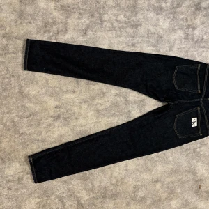 Calvin Klein Jeans - Säljer nu ett par jeans från Calvin Klein i färgen mörkblå! Modellen på jeansen är slim taper. Perfekt för dig som inte gillar för tajta eller baggy! Storlek 28x30. Använda knappt 3 gånger. Köpta i butik för 1300. 