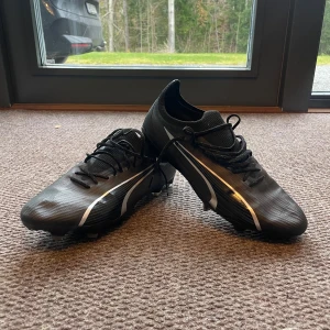 Puma Ultra - Säljer ett par svarta fotbollsskor från Puma i mycket bra skick. Använda fåtal gånger och är som nya. Nypris 1600kr