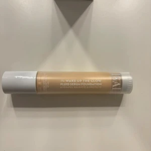 Wake Up The Glow Fluid Serum Foundation - Säljer en flaska av 'Wake Up The Glow' Fluid Serum Foundation i nyansen 3N. Denna foundation återfuktar, balanserar och skyddar huden. Perfekt för en naturlig och strålande look. Kommer i en smidig flaska med vit kork.