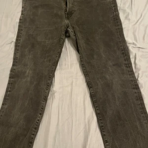 Grå jeansbyxor från H&M - Säljer ett par grå jeansbyxor från H&M i regular fit. De är i bra skick och perfekta för vardagsbruk. Byxorna har en klassisk design med dragkedja och knapp framtill. Passar bra till både höst och vår.