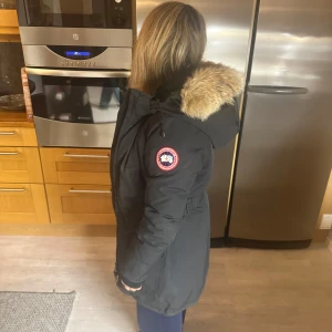 Svart Canada goose jacka - Säljer en svart Canada goose jacka. Jackan är perfekt för kalla vinterdagar och har en normal passform. Den har en snygg logga på ärmen och ser riktigt varm och skön ut. Perfekt för vinterns alla äventyr! Använd få gånger och är i storlek xxs men passar även xs och s