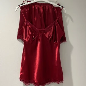 Röd satinpyjamas  - Säljer denna fina och sköna pyjamas. Endast använt en gång. (Snöret har gått av en gång så sytt på det ingen men ingen större synlighet)