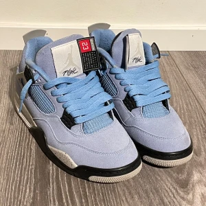 Nike Air Jordans 4 (Unc) - Tja! Säljer ett par snygga Nike Air Jordans i ljusblå mocka. Skorna har svarta och vita detaljer. Skick: 9/10 . Inget orginalet med följer alltså kommer ingen box😊. Storleken är 41 men passar 40. Priset kan diskuteras vid snabb affär☺️
