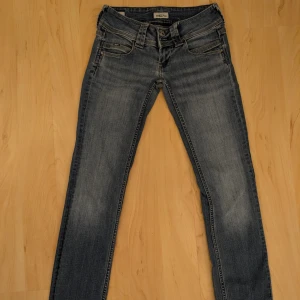 Blå jeansbyxor - Säljer ett par snygga blå low waist jeansbyxor från Pepe Jeans! De är i bra skick och passar bra till många olika toppar och jeans! 