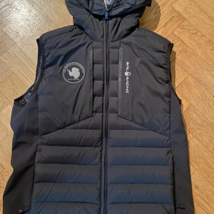 Svart väst från Sail Racing - Säljer en svart dunväst från Sail Racing storlek M.   mycket bra skick. Knappt använd. Säljer för den ej kommer till användning. Nypris 2200kr pris kan diskuteras. 