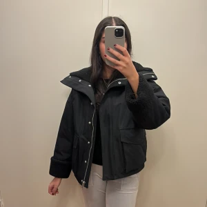 Svart jacka & Other Stories - Säljer en snygg svart jacka från & Other Stories i storlek XS. Den har en mysig teddyfoder och stängs med dragkedja och knappar. Perfekt för höst och vinter. Jackan är i mycket bra skick!