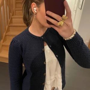 Mörkblå stickad kofta - Säljer en snygg mörkblå stickad kofta med knappar framtill. Perfekt för höst och vinter❄️💕Alla knappar sitter ordentligt. Stl 152, alltså barn storlek men passar som XXS-S😊 skriv vid frågor