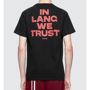 Svart t-shirt med tryck från Helmut Lang - Säljer en svart t-shirt från Helmut Lang i bomull. Den har ett coolt tryck med texten 'IN LANG WE TRUST' på ryggen och 'HELMUT' på bröstet i rött. Perfekt för en avslappnad stil eller streetwear-look. Passar bra till både jeans och shorts! Kontakta för mer info eller bilder på mig❣️