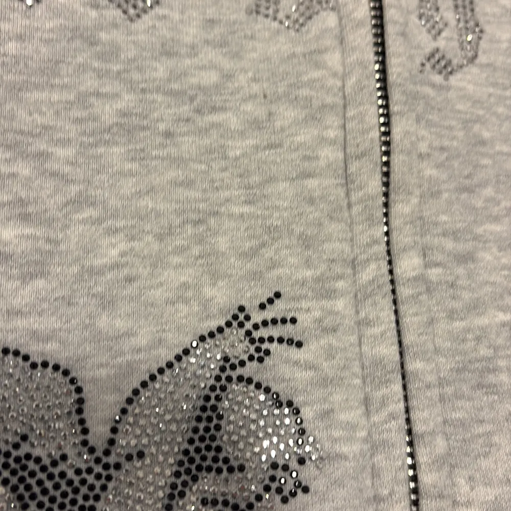 Säljer en grå rhinestone hoodie från märket ”side by side”. Tröjan är i bra skick där alla dialekter sitter kvar förutom en som syns på sista bilden. Det är absolut inte man tänker på när man ser den. Tröjan är riktigt skön att ha på sig och passar till det mesta. Tröjor & Koftor.