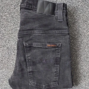 Svarta jeans från Nudie Jeans - Säljer ett par svarta jeans från Nudie Jeans i mycket bra skick. De är storleken L-32—W-32. Inga skador eller fläckar. Perfekta för höst och vinter! Pris kan diskuteras vid snabb affär 
