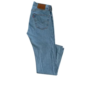 Levi's 501 Jeans i ljusblå denim - Säljer ett par klassiska Levi's 501 jeans i ljusblå denim. De har en rak passform och är i mycket bra skick, bara använda ett fåtal gånger. Supersnygga och perfekta jeans för alla tillfällen!