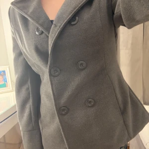 Grå kappa från Savida - Snygg grå kappa  i mycket bra skick. De är  klassisk kappa modell som är elegant. Perfekt för höst och vår, med en figursydd passform som ger en elegant look. Passar både till vardags och lite finare tillfällen. Den är i storlek L men passar mig med storlek 38 perfekt 