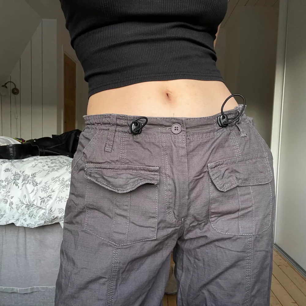 lågmidjade grå cargobyxor i loose fit med justerbar midja, endast använda 2-3 ggr! 101cm långa och 76cm i midjan (men justerbar & elastisk så passar även större och mindre). Jeans & Byxor.